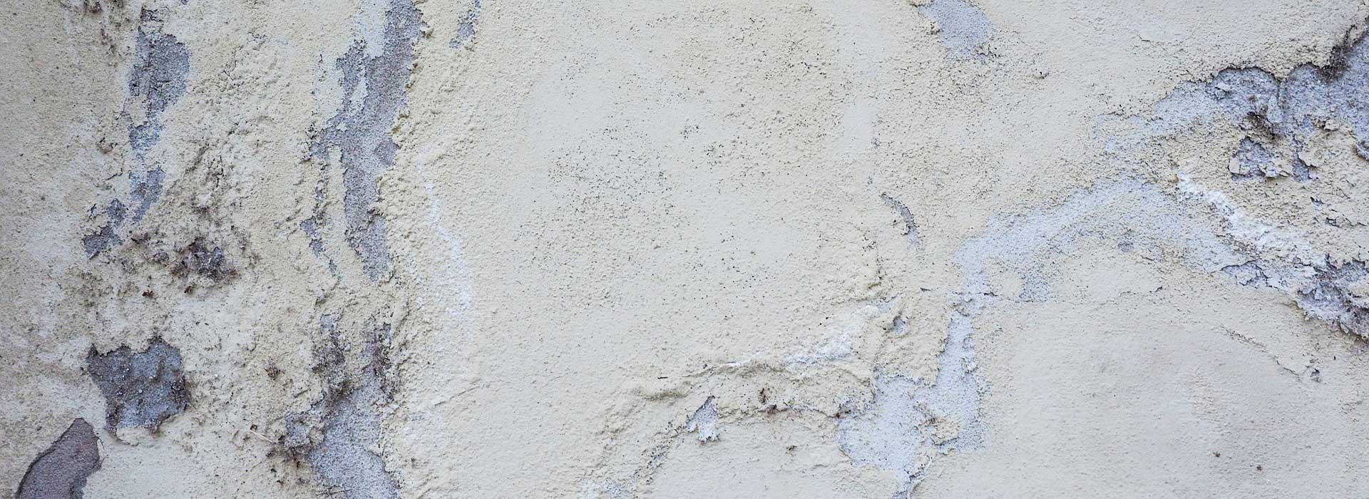 Penetrating damp staining on exterior rendered wall showing water ingress and moisture damage
